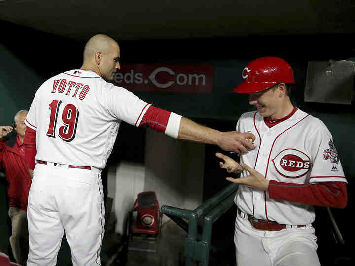 Normally reclusive Cincinnati Reds first baseman Joey Votto (19) jokes with the bat boy by handing him more bubble gum than he can handle with one hand in the sixth inning during a game against the New York Mets at Great American Ball Park in Cincinnati.   (Kareem Elgazzar / The Cincinnati Enquirer)